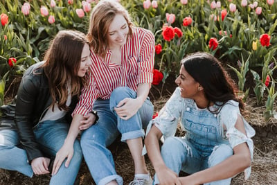 three egg donors sitting in a field of flowers