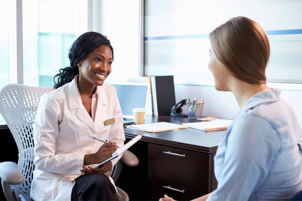 doctor-in-consultation-with-female-patient-in-offi-PD3N7KW