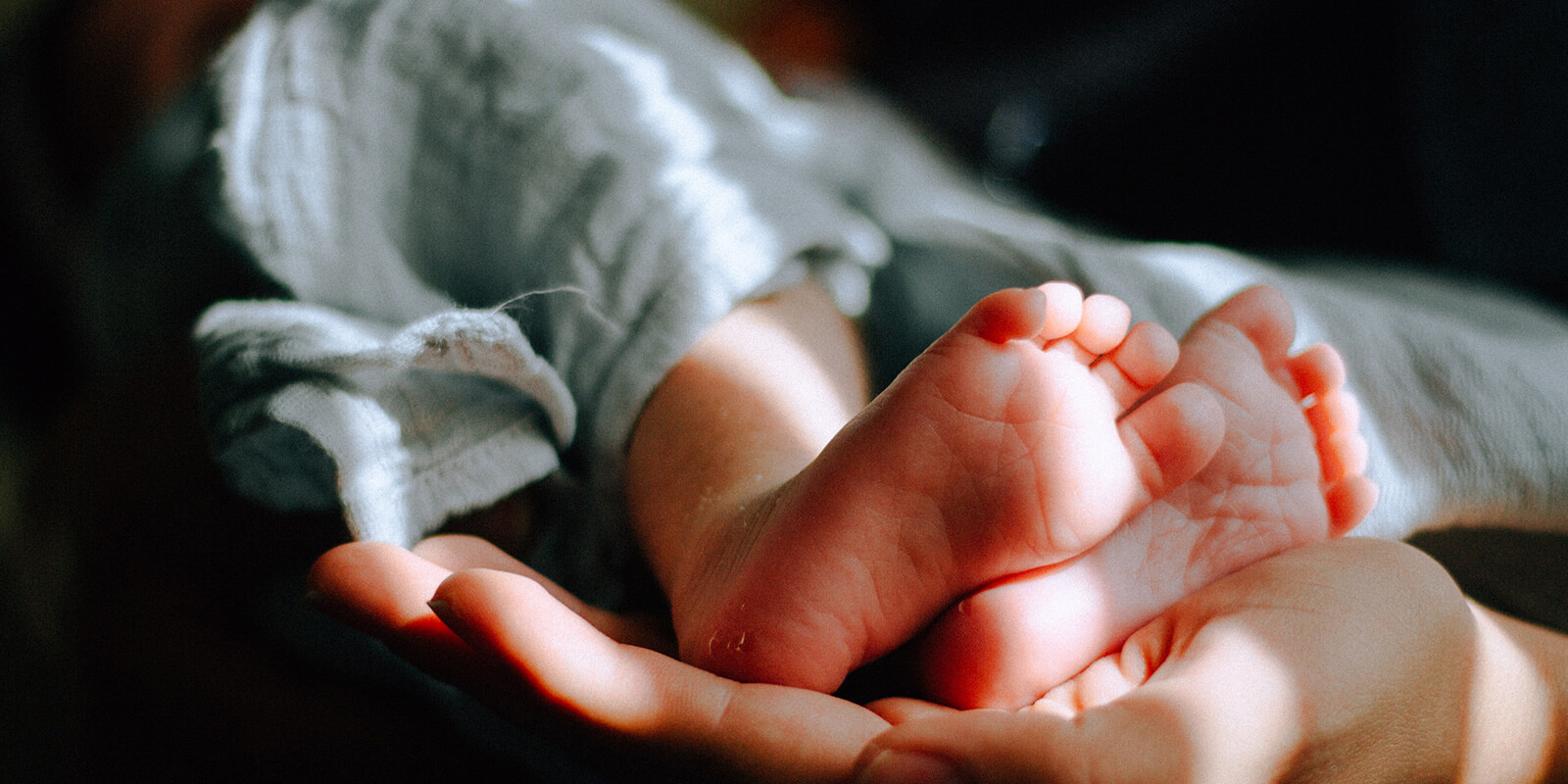 intended parent holding baby feet