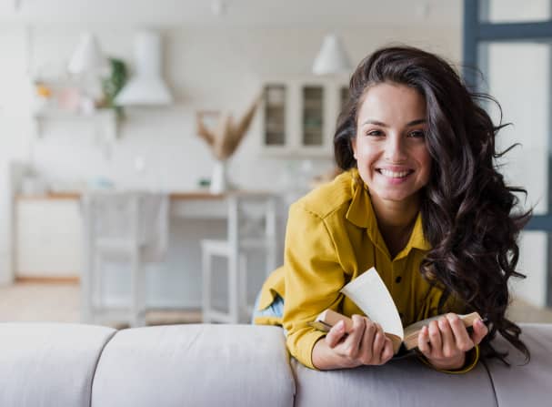 woman reading book on a couch